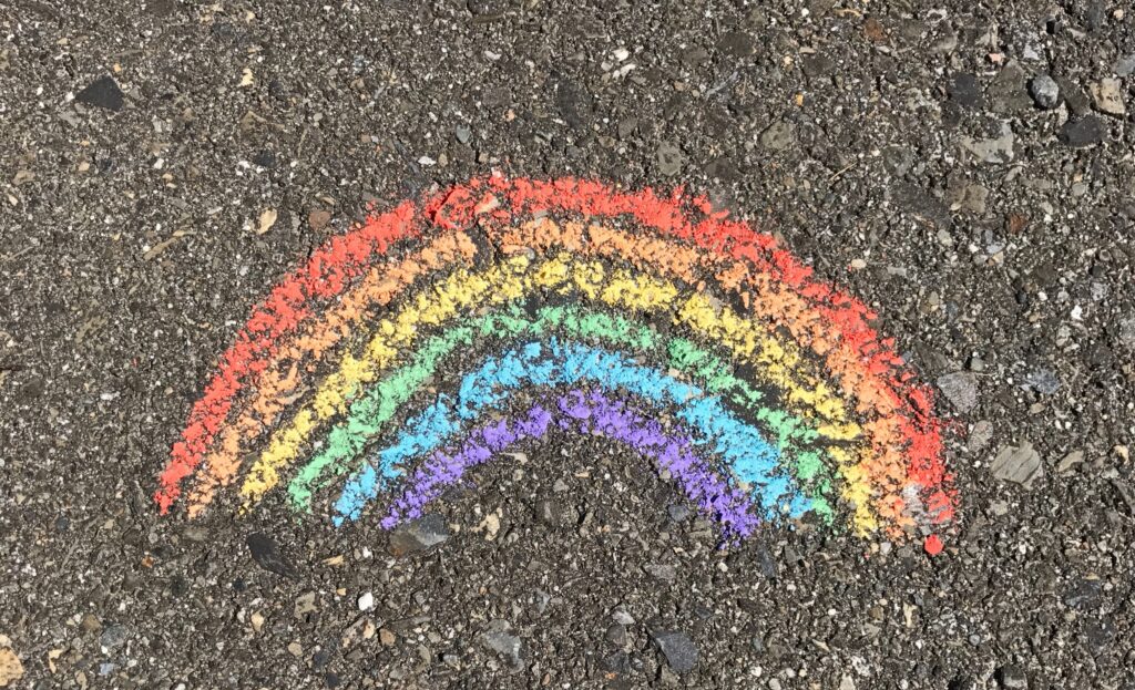 Paillettes et Arc-en-Ciel - vers une éducation coopérative et des enfants épanouis - Photo d'un arc-en-ciel dessiné à la craie sur le bitume